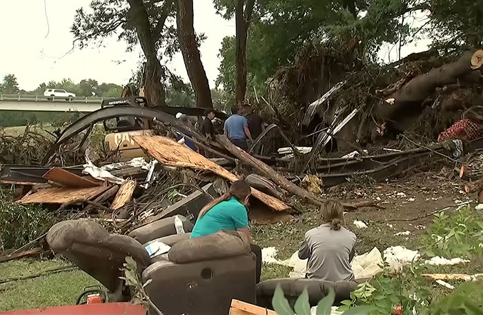 People sitting near debris and wreckage in flood aftermath, reflecting on the fear experienced by the young flood victim. People sitting near debris and wreckage in flood aftermath, reflecting on the fear experienced by the young flood victim.