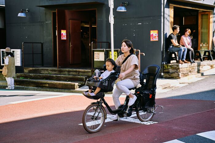 A woman rides a bike with a child in front, illustrating people share reasons not divorced through family connection.