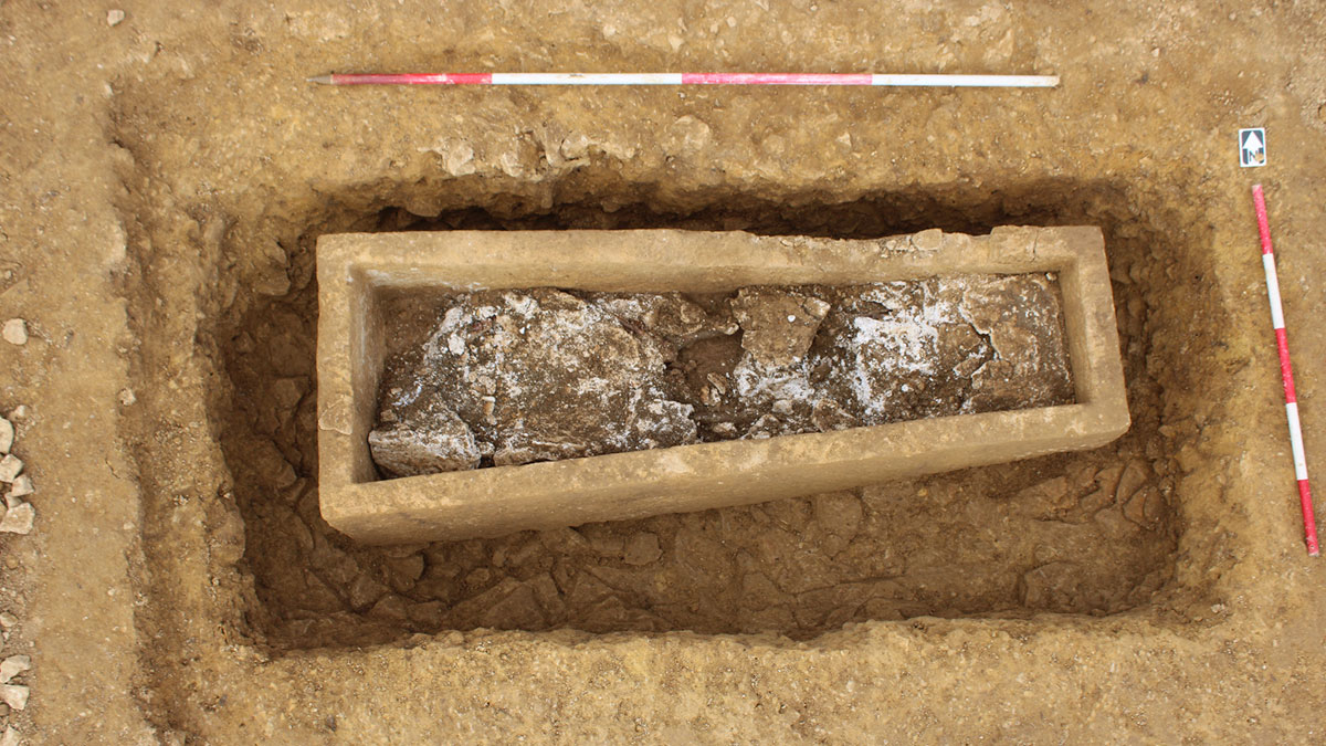 Excavation site revealing a Roman Empire and Iron Age stone coffin uncovered during highway construction.