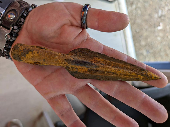 Hand holding an ancient iron spearhead, a major historical finding from Roman Empire and Iron Age excavation. Hand holding an ancient iron spearhead, a major historical finding from Roman Empire and Iron Age excavation.
