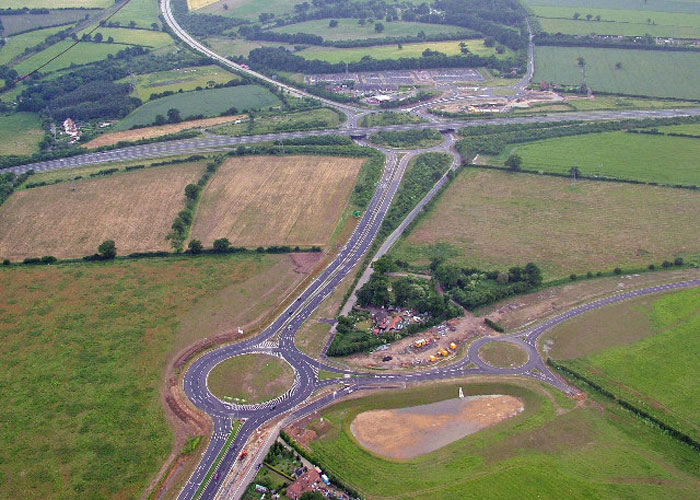 Aerial view of highway construction near green fields with major historical findings from the Roman Empire and Iron Age discovered. Aerial view of highway construction near green fields with major historical findings from the Roman Empire and Iron Age discovered.