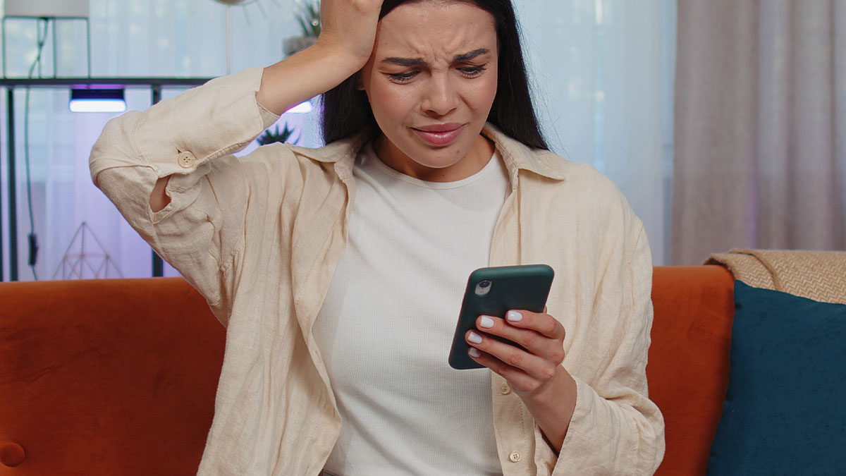 Young woman looking stressed while using smartphone, depicting reactions to entitled parents memes.