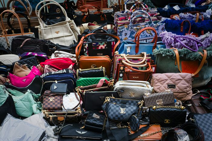 Various designer handbags displayed together, illustrating trends leading to overconsumption and consumer excess.