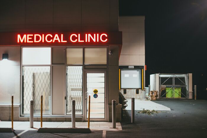Medical clinic entrance at night with illuminated red sign, highlighting common debunked lies people believe about healthcare.