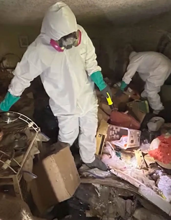 Forensic investigators in protective suits uncover skeletal remains amid trash in a hoarder ex-cop house investigation. Forensic investigators in protective suits uncover skeletal remains amid trash in a hoarder ex-cop house investigation.