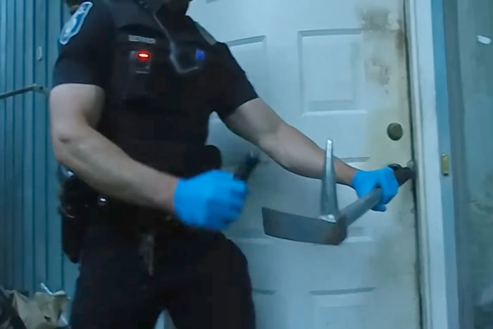 Police officer wearing gloves using a crowbar to enter a cluttered house during a skeletal remains investigation. Police officer wearing gloves using a crowbar to enter a cluttered house during a skeletal remains investigation.