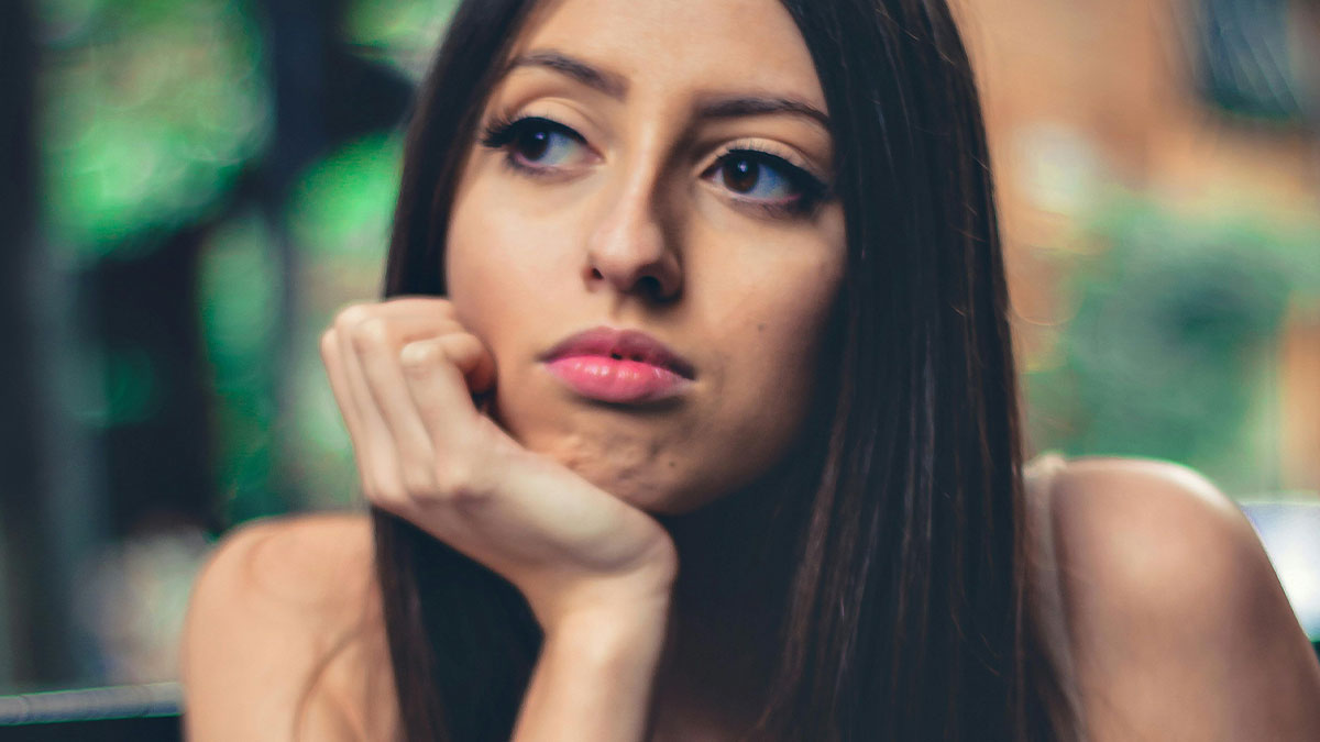 Young woman looking thoughtful and concerned, reflecting on meeting her ex and co-parenting a secret child.