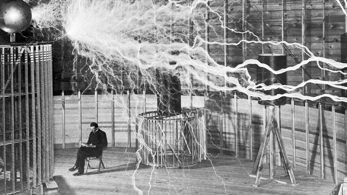 Nikola Tesla demonstrating electrical discharges with Tesla coil in a rare and interesting historical photograph.