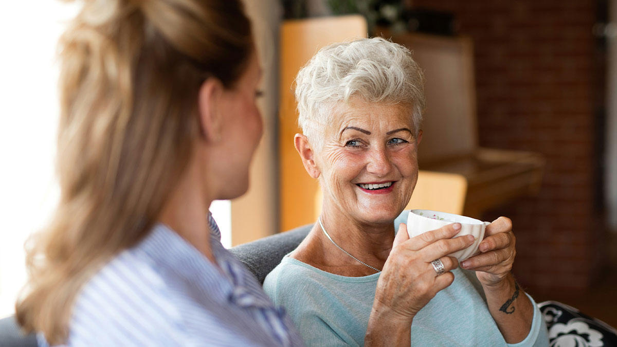Woman sipping tea and smiling, reflecting on the family heirloom from her mother-in-law worth only $30.