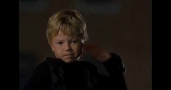 Young boy in dark clothing with a serious expression, representing cinematic crimes in the worst movie sequels.