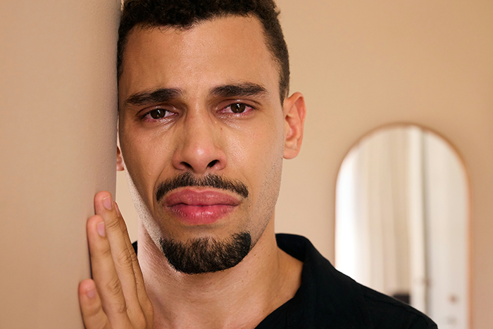 Man with a tearful expression leaning against a wall, depicting emotions related to cheating accusation and DNA test forgiveness. Man with a tearful expression leaning against a wall, depicting emotions related to cheating accusation and DNA test forgiveness.