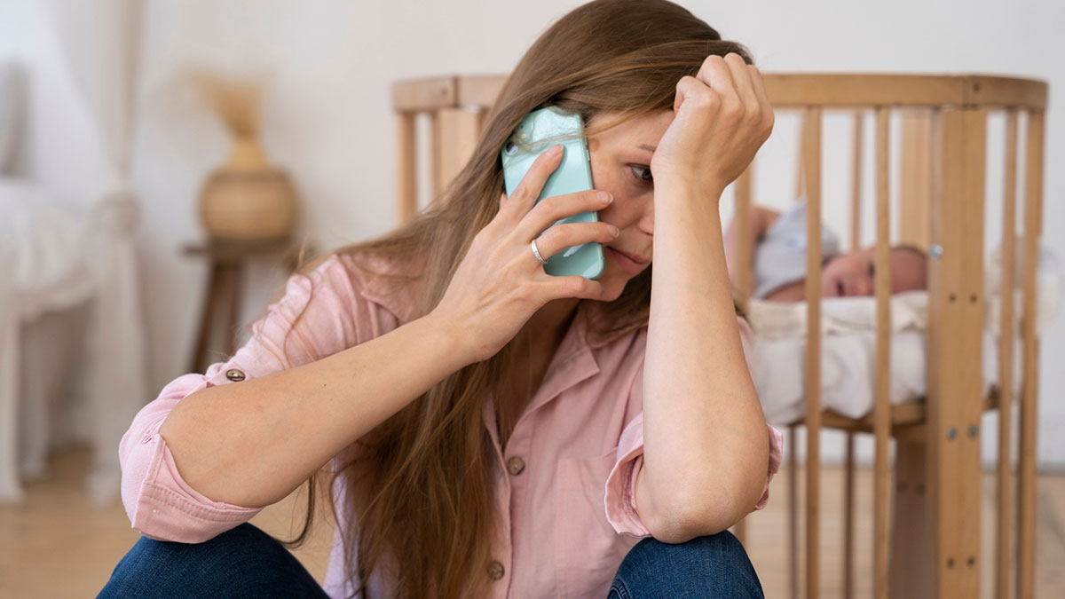 Frustrated woman on phone near baby crib, upset about grandpa skipping babysitting duty for party weekend