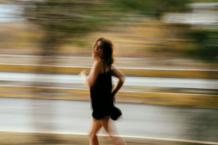Blurry image of a woman in motion outdoors, illustrating McDonald's employees' bizarre experiences and fast-paced work life.
