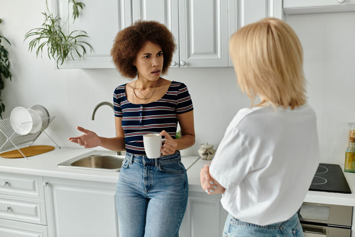 Woman confronts roommate in kitchen after finding contractors quoting jobs for home remodel plot. Woman confronts roommate in kitchen after finding contractors quoting jobs for home remodel plot.