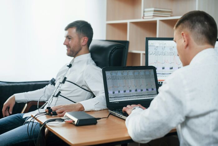Man undergoing a polygraph test as technician monitors results, illustrating debunked lies people believe about truth detection.