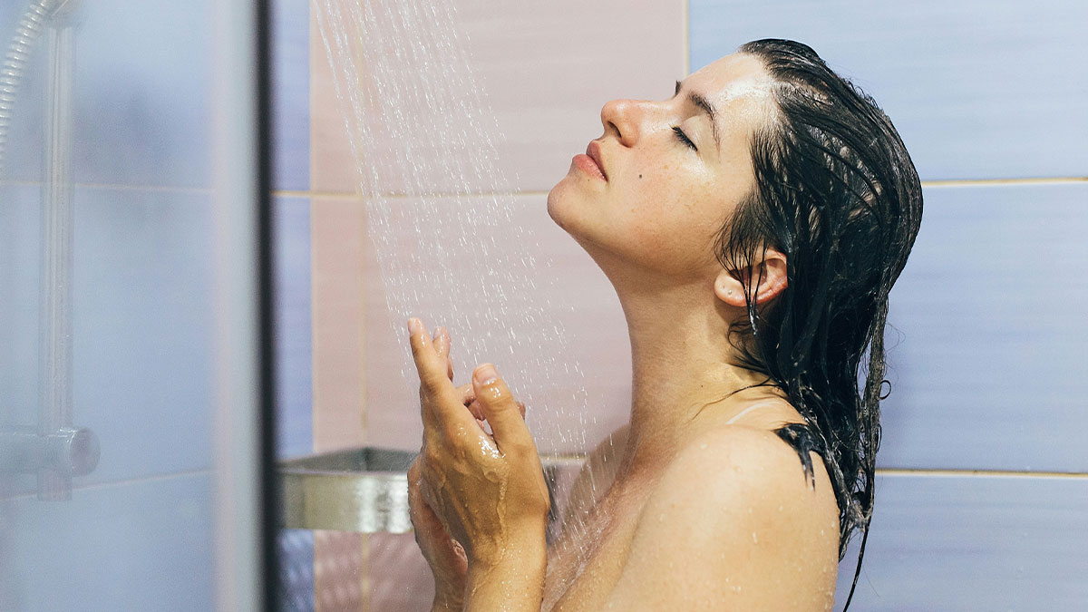 Young woman with wet hair enjoying a shower, representing confusion over girlfriend not visiting in the mornings and drama with mom