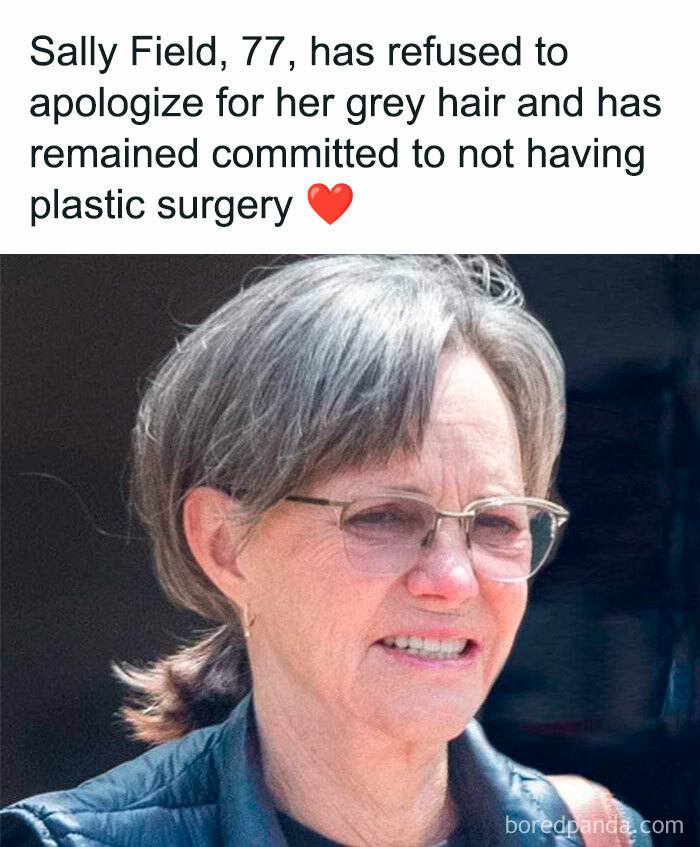 Older woman with grey hair and glasses smiling naturally, embracing the good old days without plastic surgery.