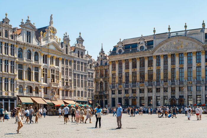 Tourists walking in a historic European square surrounded by ornate buildings in one of the smartest countries shaping the future
