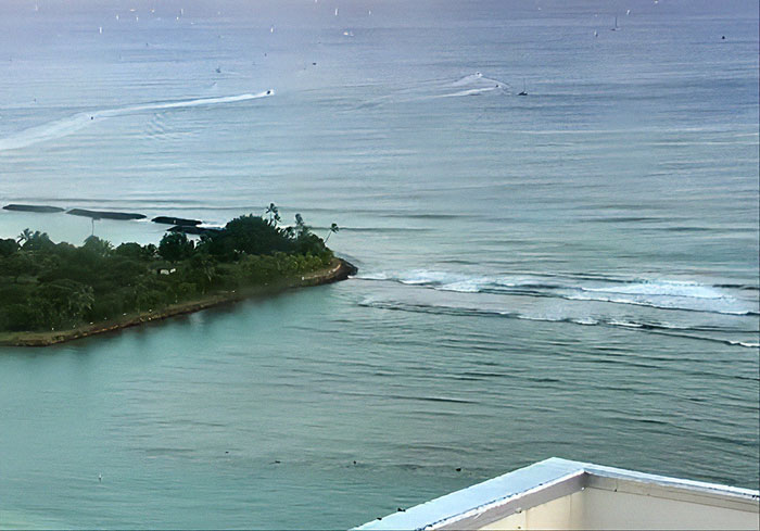 Coastal view of calm ocean waters and small island, illustrating the setting for an oncoming tsunami escape scenario. Coastal view of calm ocean waters and small island, illustrating the setting for an oncoming tsunami escape scenario.