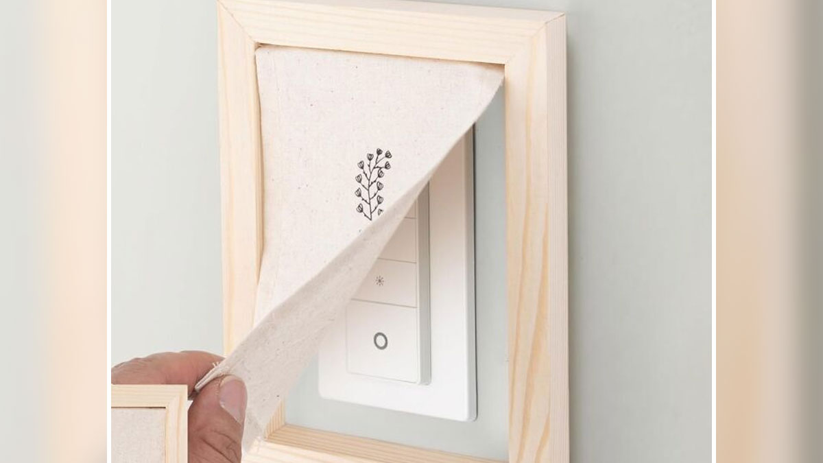 Hand covering an eyesore in the home with a fabric flap framed in wood as a sneaky home decor solution.