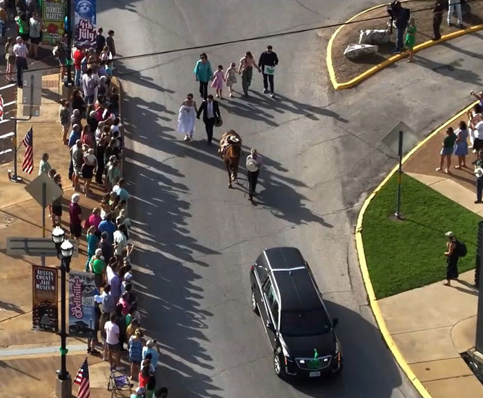 Horse walks behind hearse in a procession, wearing a tiny hat and boots after Camp Mystic tragedy. Horse walks behind hearse in a procession, wearing a tiny hat and boots after Camp Mystic tragedy.