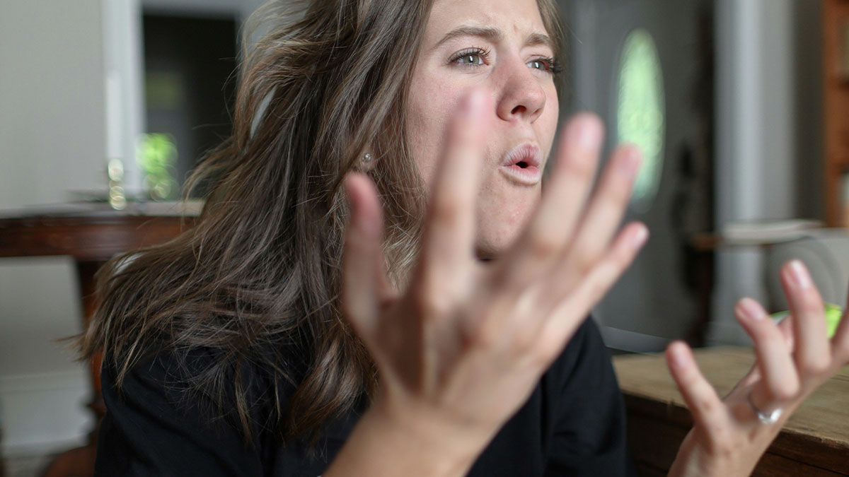 Woman expressing shock and frustration indoors, reacting to husband comes home after months of absence.