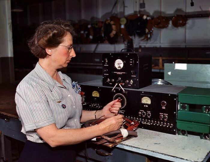 Woman operating electronic equipment, showcasing the bold and brilliant world of women at work during WWII.