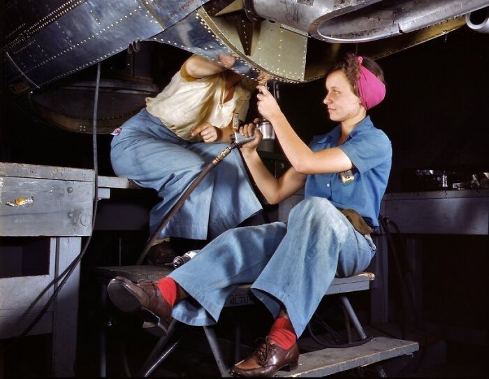 Women at work during WWII repairing aircraft, showcasing the bold and brilliant role of women in wartime industry.