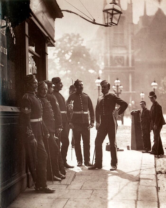 Group of Victorian-era men in uniform standing on a London street, showing how London's poorest really lived in the 1800s.