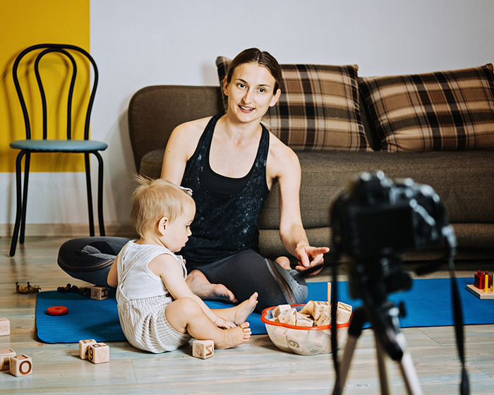 Momfluencer filming staged playtime with toddler indoors, facing backlash for pretending to create authentic content. Momfluencer filming staged playtime with toddler indoors, facing backlash for pretending to create authentic content.