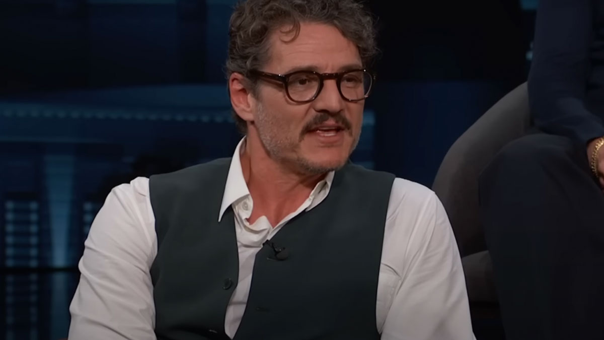 Man with glasses and mustache speaking during a celebrity encounter, wearing a white shirt and dark vest in an interview setting