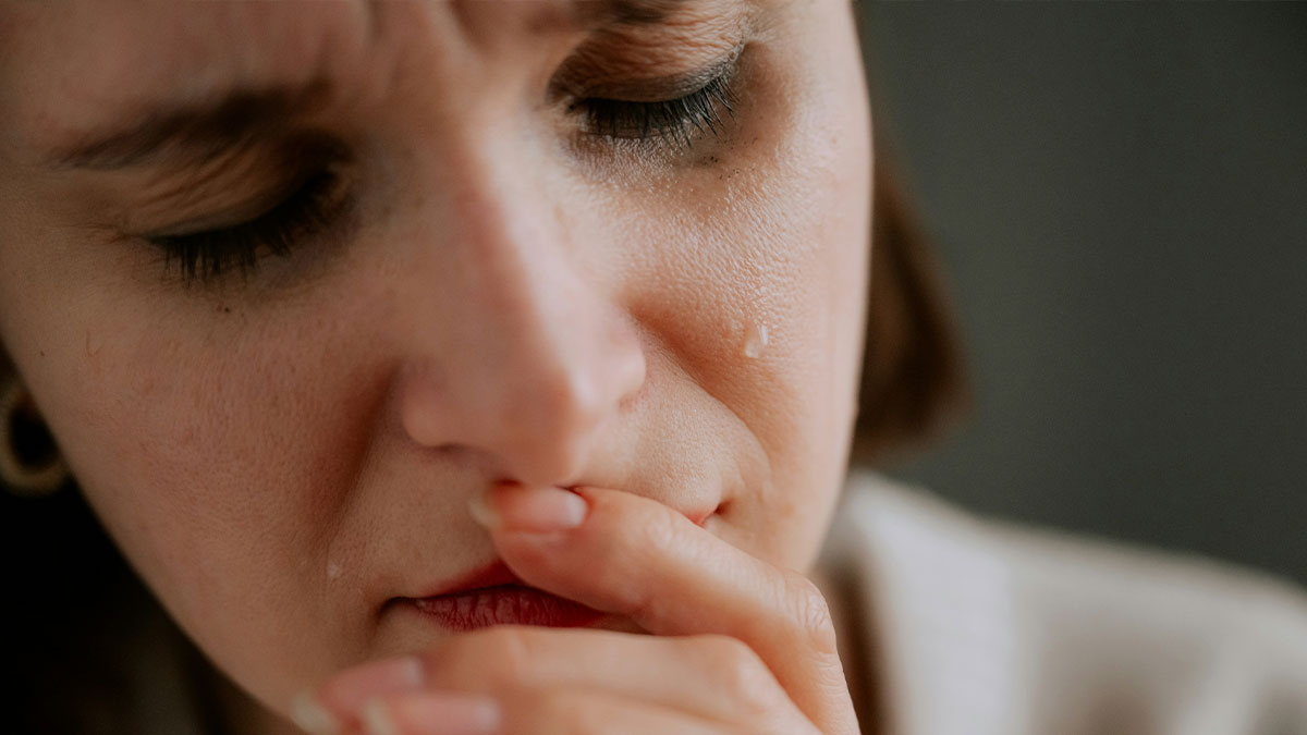 Close-up of a woman with tears on her face, reflecting on backlash for not inviting nephew on vacay after past trip bailouts.