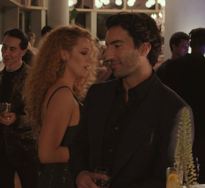 Blake Lively at a social event, dressed elegantly, engaging in conversation with attendees in a dimly lit room. Blake Lively at a social event, dressed elegantly, engaging in conversation with attendees in a dimly lit room.