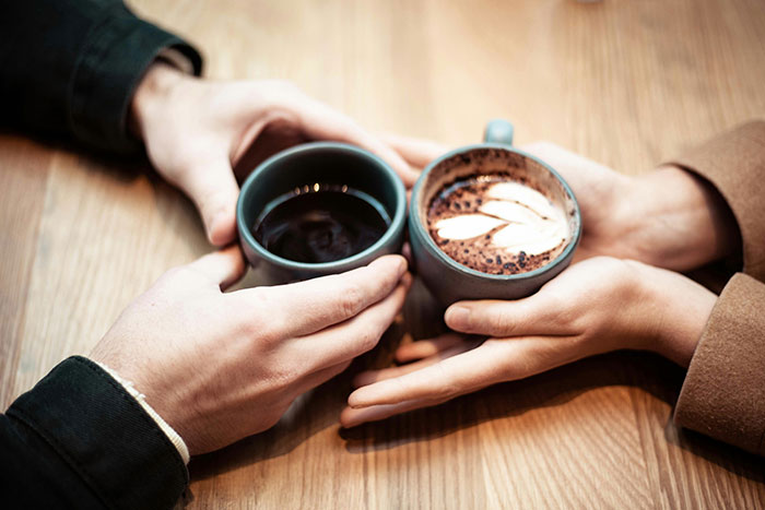 Two people holding coffee cups together symbolizing relationship and divorce delay after affair partner's loss in crash. Two people holding coffee cups together symbolizing relationship and divorce delay after affair partner's loss in crash.