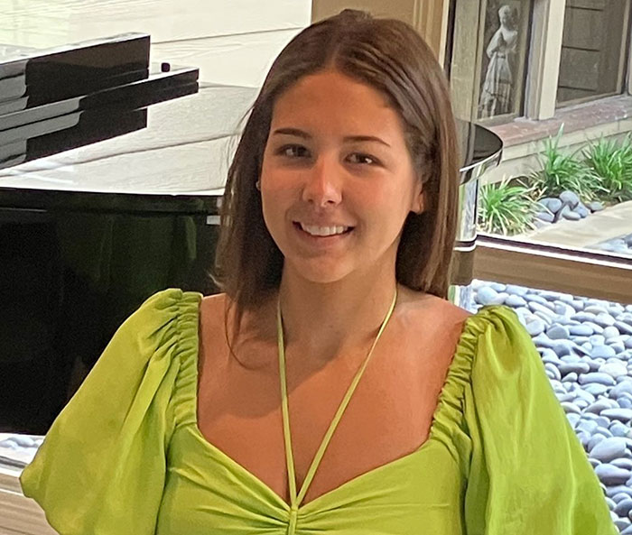 Young flood victim smiling indoors near a piano and window with rocks and greenery outside. Young flood victim smiling indoors near a piano and window with rocks and greenery outside.