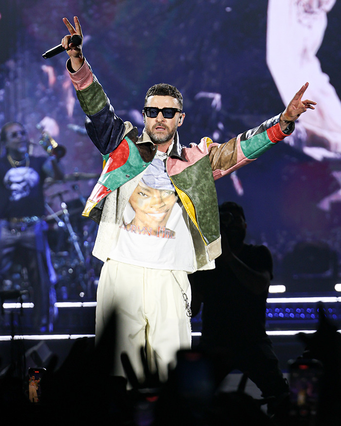 Justin Timberlake performing on stage, wearing sunglasses and colorful jacket, revealing Lyme disease battle after Romania show. Justin Timberlake performing on stage, wearing sunglasses and colorful jacket, revealing Lyme disease battle after Romania show.