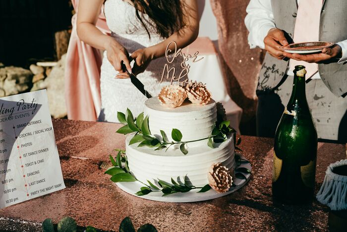 Couple cutting wedding cake with floral decorations and champagne, symbolizing moments before relationship changes.