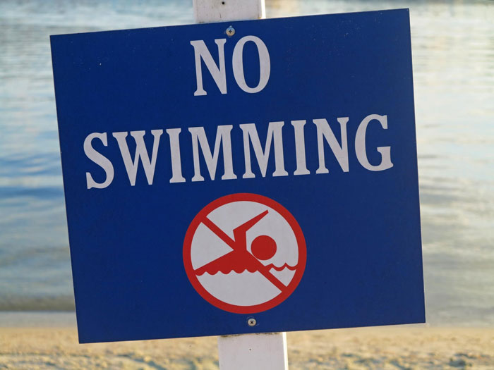 No swimming sign at a hotel pool, referencing karens kid poop, warning guests to avoid swimming in the pool water.