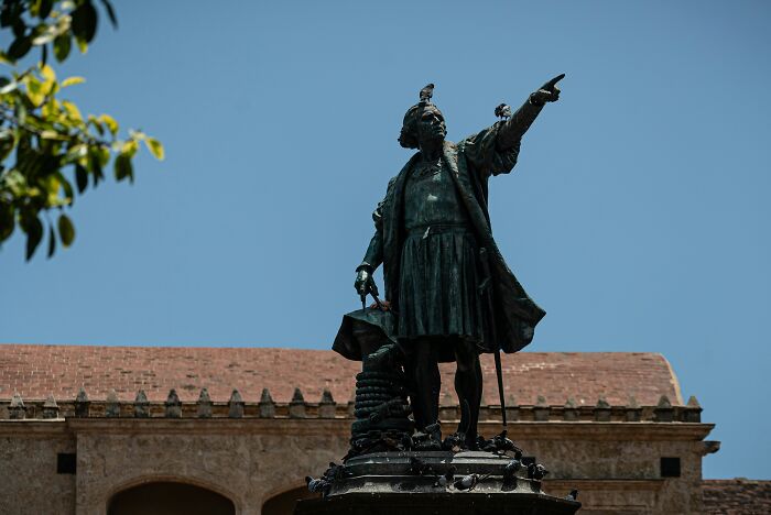Statue of a historic explorer pointing forward under clear sky, illustrating common lies that have been proven false repeatedly.