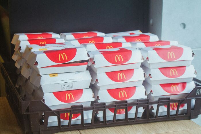 Stack of McDonald's burger boxes on a tray representing McDonald's employees' bizarre work experiences.
