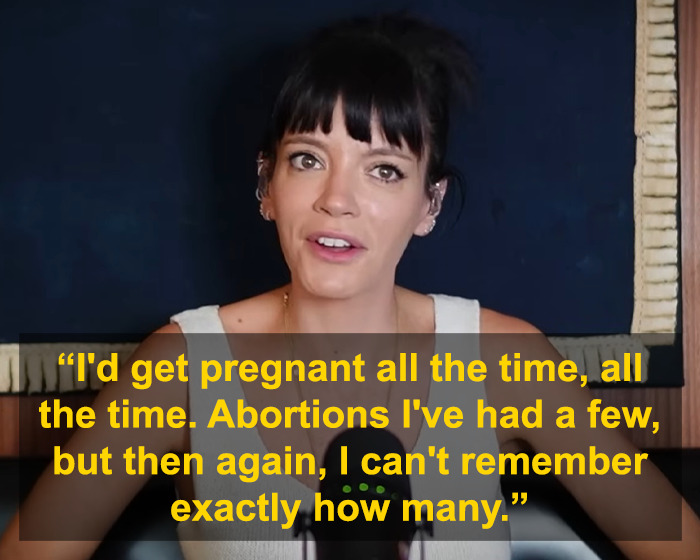 Lily Allen speaking about her abortions in a candid interview, with a dark background behind her.