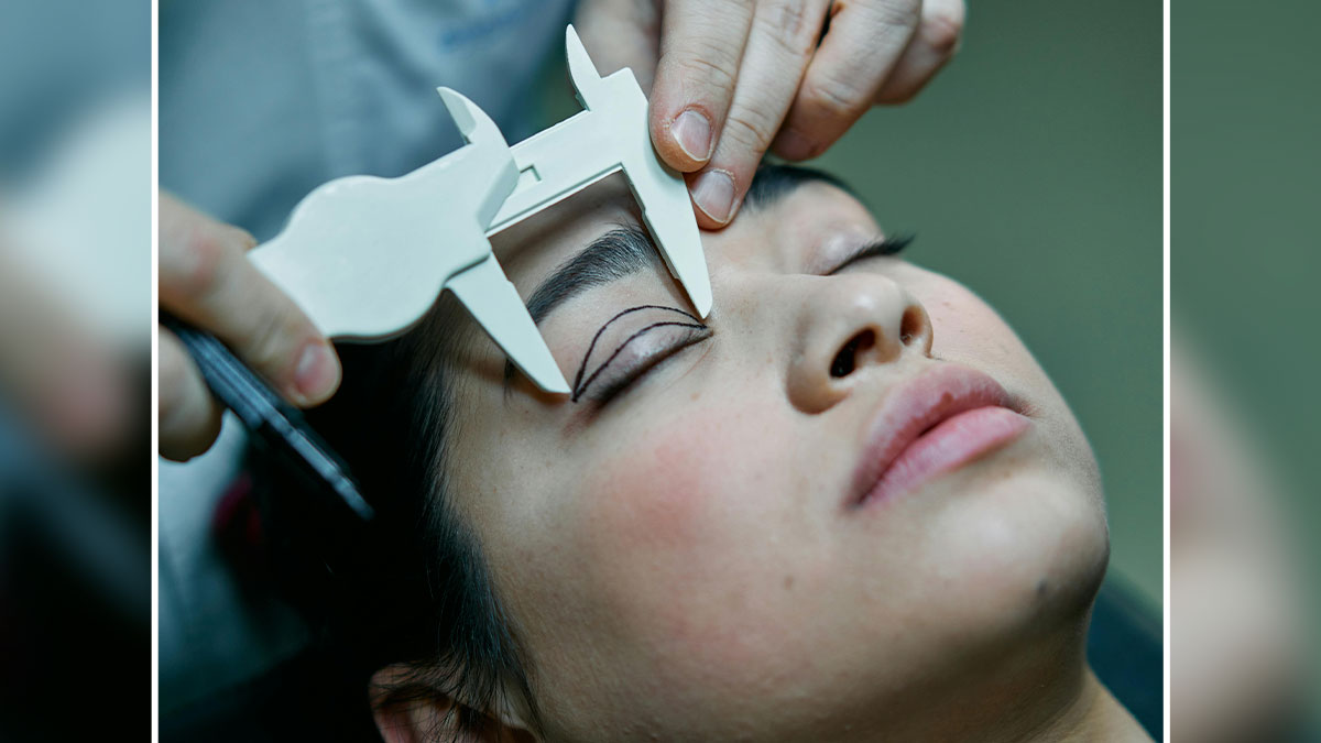 Close-up of womanu2019s eyelid being measured with calipers for plastic surgery to achieve an Asian child look.