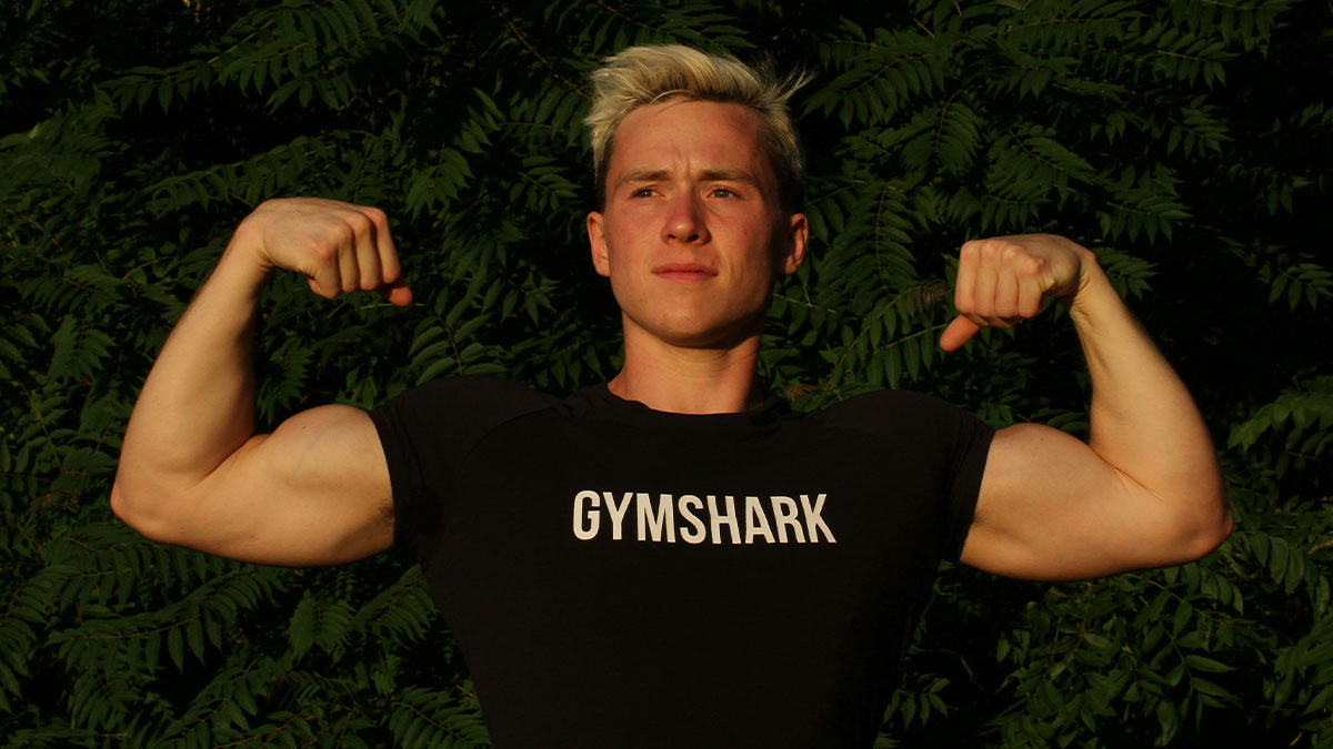Young man flexing muscles outdoors, illustrating themes of personal space invasion and modern social conflicts.
