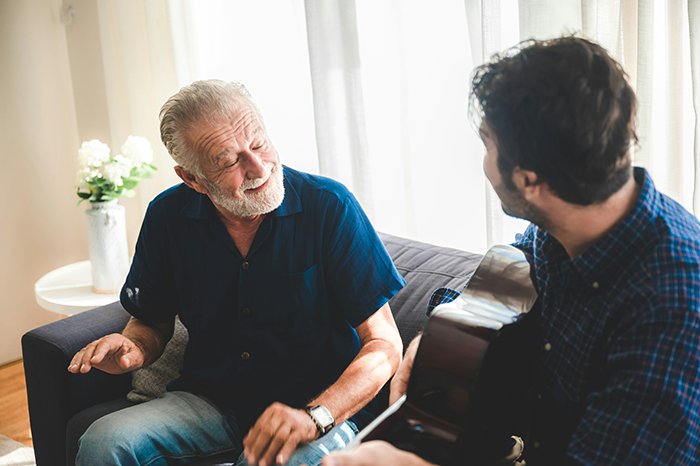 Older retiree and younger neighbor sharing a moment in apartment, highlighting unexpected quiet retiree passing story.