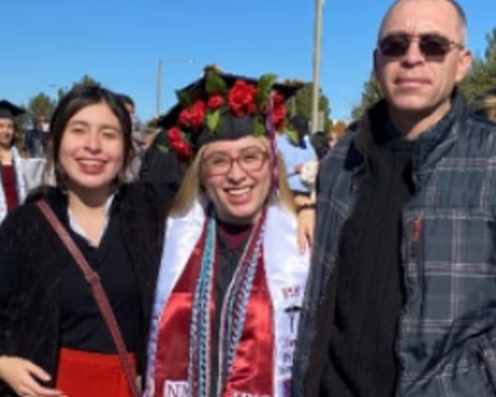 Three people smiling outdoors, with a woman in graduation attire, unrelated to man slays family dog news. Three people smiling outdoors, with a woman in graduation attire, unrelated to man slays family dog news.