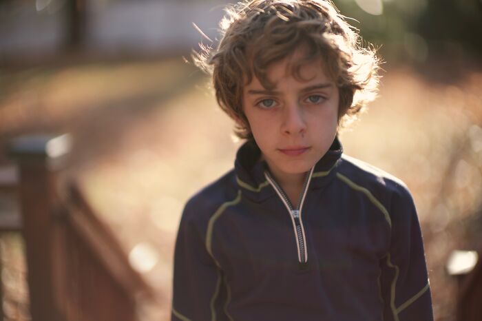 Sad young boy outdoors in soft light reflecting on advice kids were given that revealed manipulation later in life.