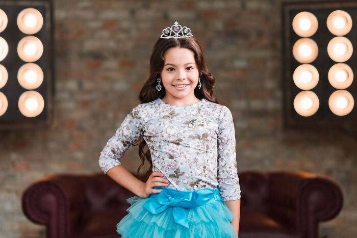 Young girl wearing a tiara and blue tutu posing confidently, representing advice kids were given and manipulation in disguise
