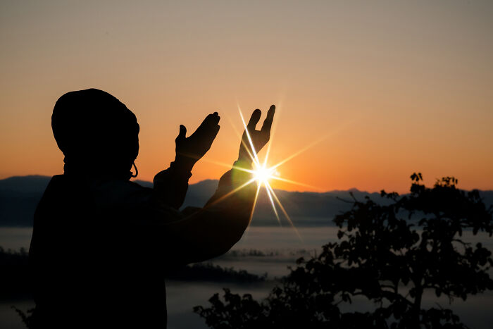 Silhouette of a child reaching towards the sunrise, symbolizing advice kids were given that felt like manipulation.