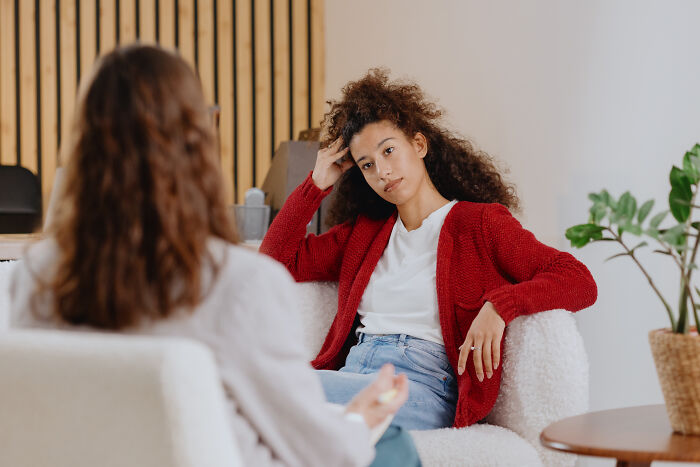Young woman in a red cardigan reflecting during a conversation about advice kids were given and manipulation in disguise.