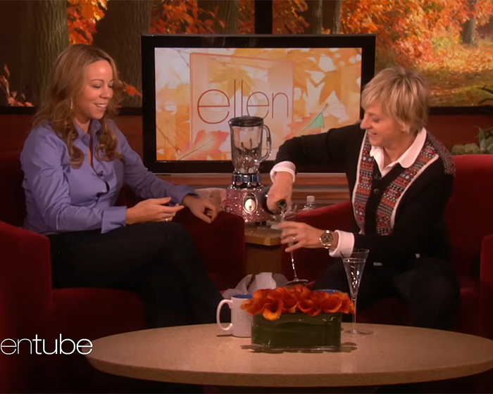 Ellen DeGeneres pouring a drink while interviewing Mariah Carey during a daytime talk show segment indoors. Ellen DeGeneres pouring a drink while interviewing Mariah Carey during a daytime talk show segment indoors.